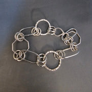 Silver link bracelet with different shapes and sizes.
