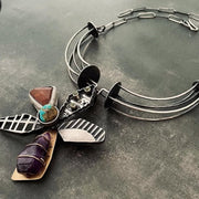 Silver necklace with stone charms on a gray surface