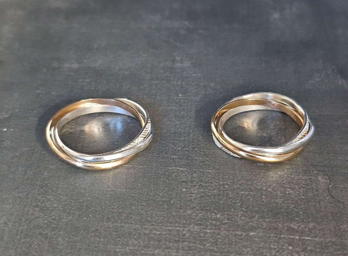 Two Russian rolling rings of interlocking gold and silver bands