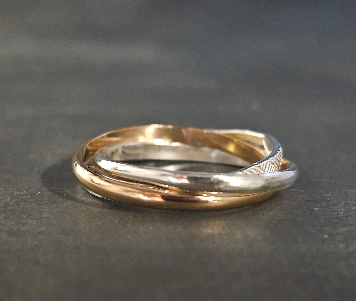 Gold and silver ring on a dark gray background