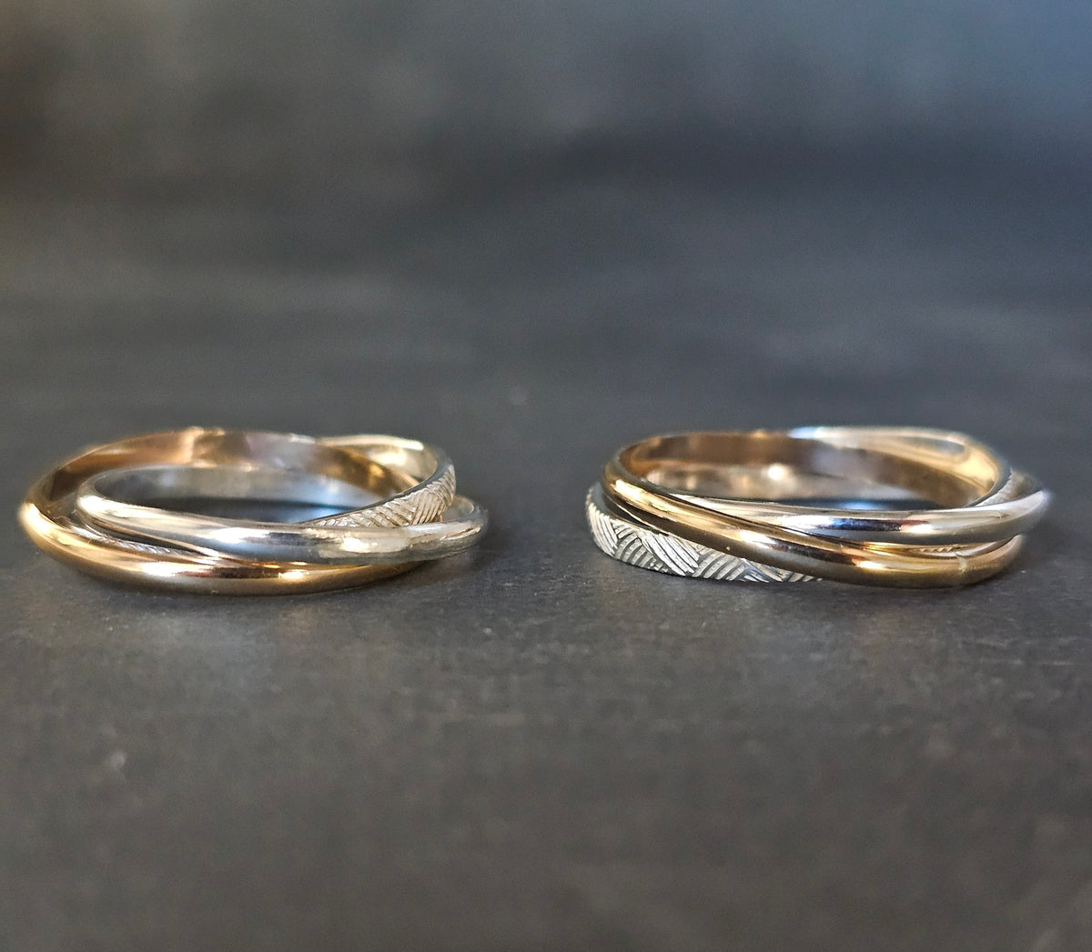 Two Russian rolling rings in mixed gold and silver, one with a textured band