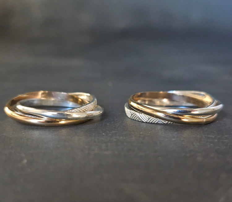 Two Russian rolling rings in mixed gold and silver, one with a textured band